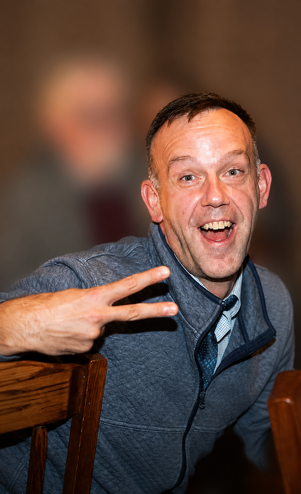 Scott R. Prelewicz laughing and giving a peace sign